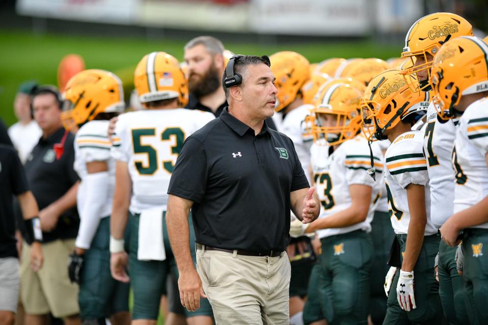 Blackhawk's new head coach Pat Feeley talks to his players before the Cougars' game against Beaver Falls Friday night at Reeves Field at Geneva College.