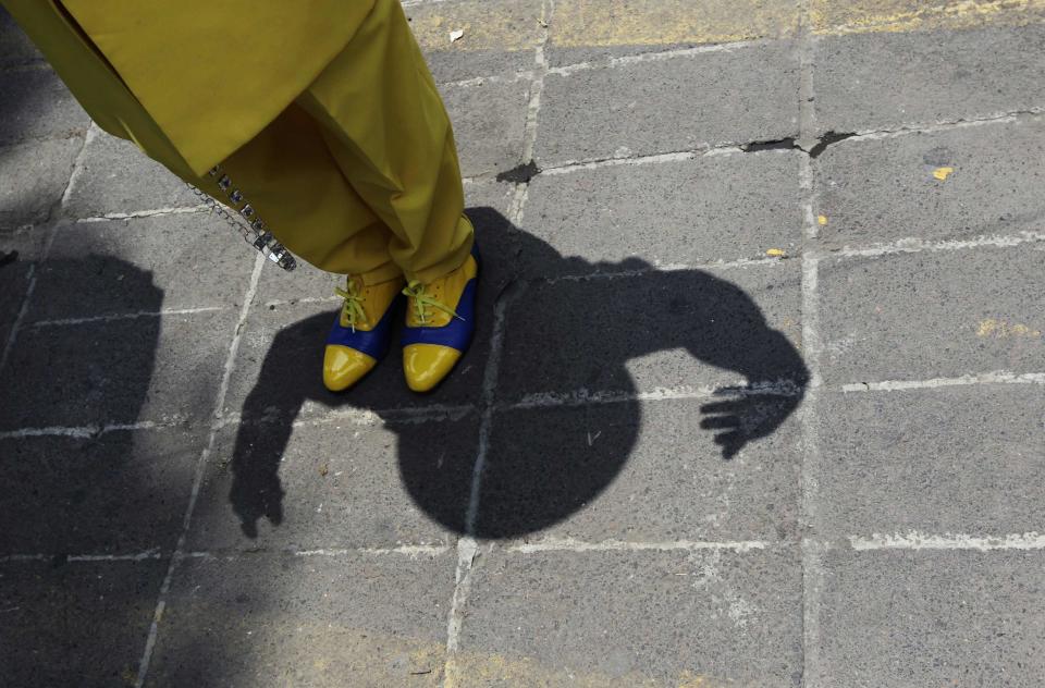 Man dressed in "Pachuco" style casts his shadow while gesturing in Mexico City