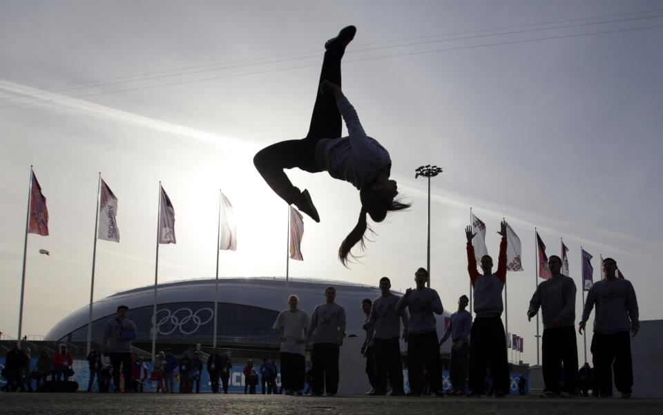 Nino Deisadze, an actress with the acrobatic group Jump Evolution, performs a backflip in front of the Bolshoy Ice Dome while entertaining spectators in the Olympic Park at the 2014 Winter Olympics, Feb. 20, 2014, in Sochi, Russia.