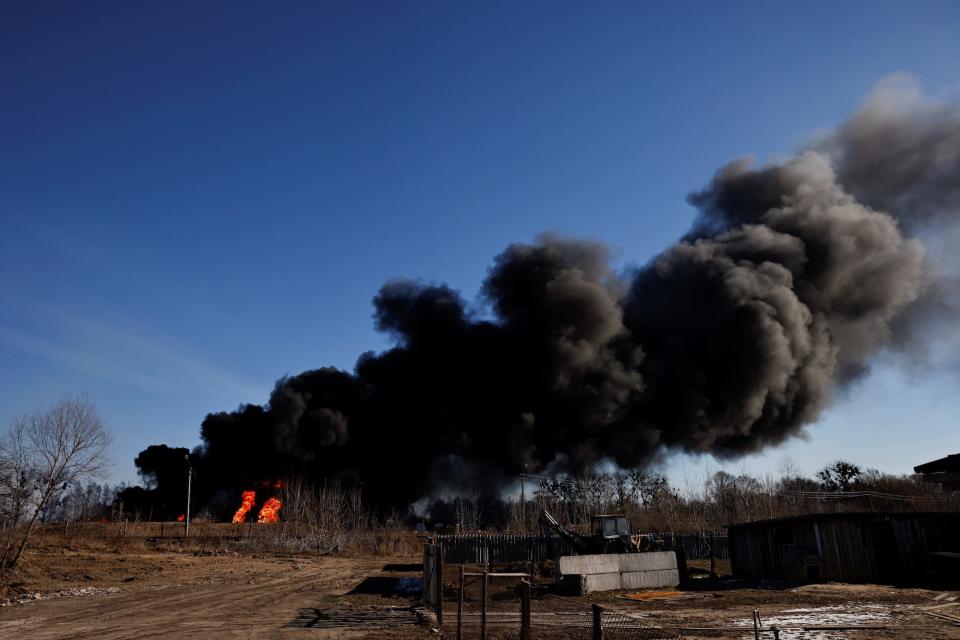 A column of smoke rises from burning fuel tanks that locals said were hit by five rockets at the Vasylkiv Air Base, following Russia's invasion of Ukraine, outside Kyiv, Ukraine, March 12, 2022.