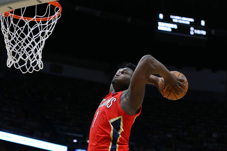 Zion Williamson goes up for a two-handed dunk during a game.