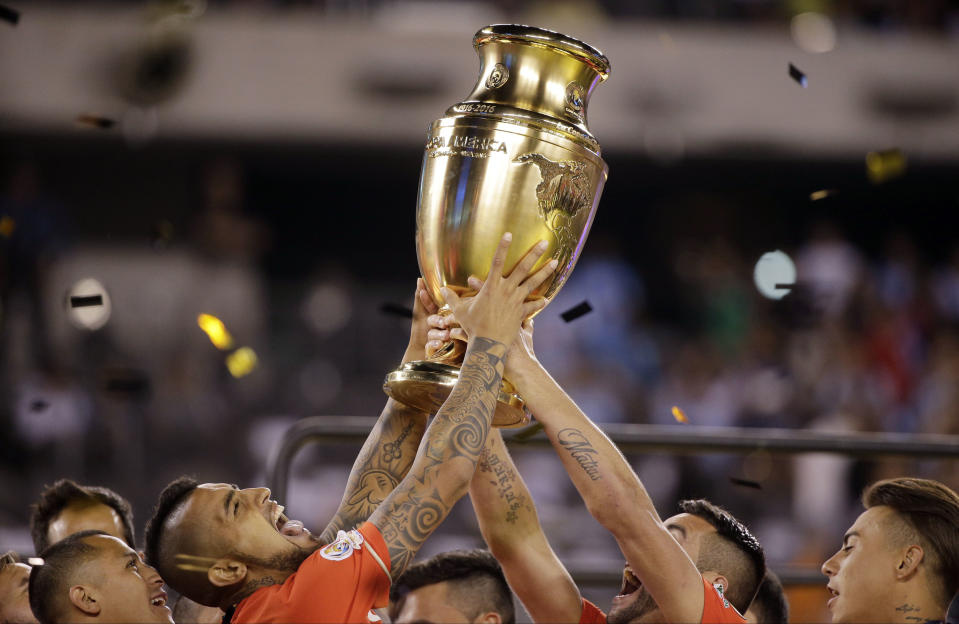 Chile&#39;s Arturo Vidal, second left, holds up the championship trophy after the Copa America Centenario championship soccer match, Sunday, June 26, 2016, in East Rutherford, N.J. Chile defeated Argentina 4-2 in penalty kicks to win the championship. (AP Photo/Julie Jacobson)