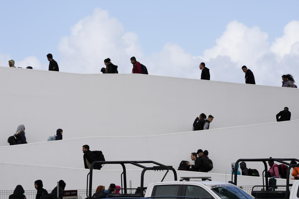 People cross into the United States for their appointments to seek asylum made through the CBP One app, Friday, Feb. 2, 2024, in Tijuana, Mexico. (AP Photo/Gregory Bull)