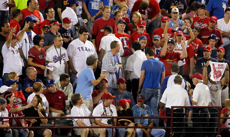 ARLINGTON, TX - OCTOBER 22: A fan is escorted out by security after throwing a baseball onto the field in the seventh inning during Game Three of the MLB World Series between the St. Louis Cardinals and the Texas Rangers at Rangers Ballpark in Arlington on October 22, 2011 in Arlington, Texas. (Photo by Tom Pennington/Getty Images)