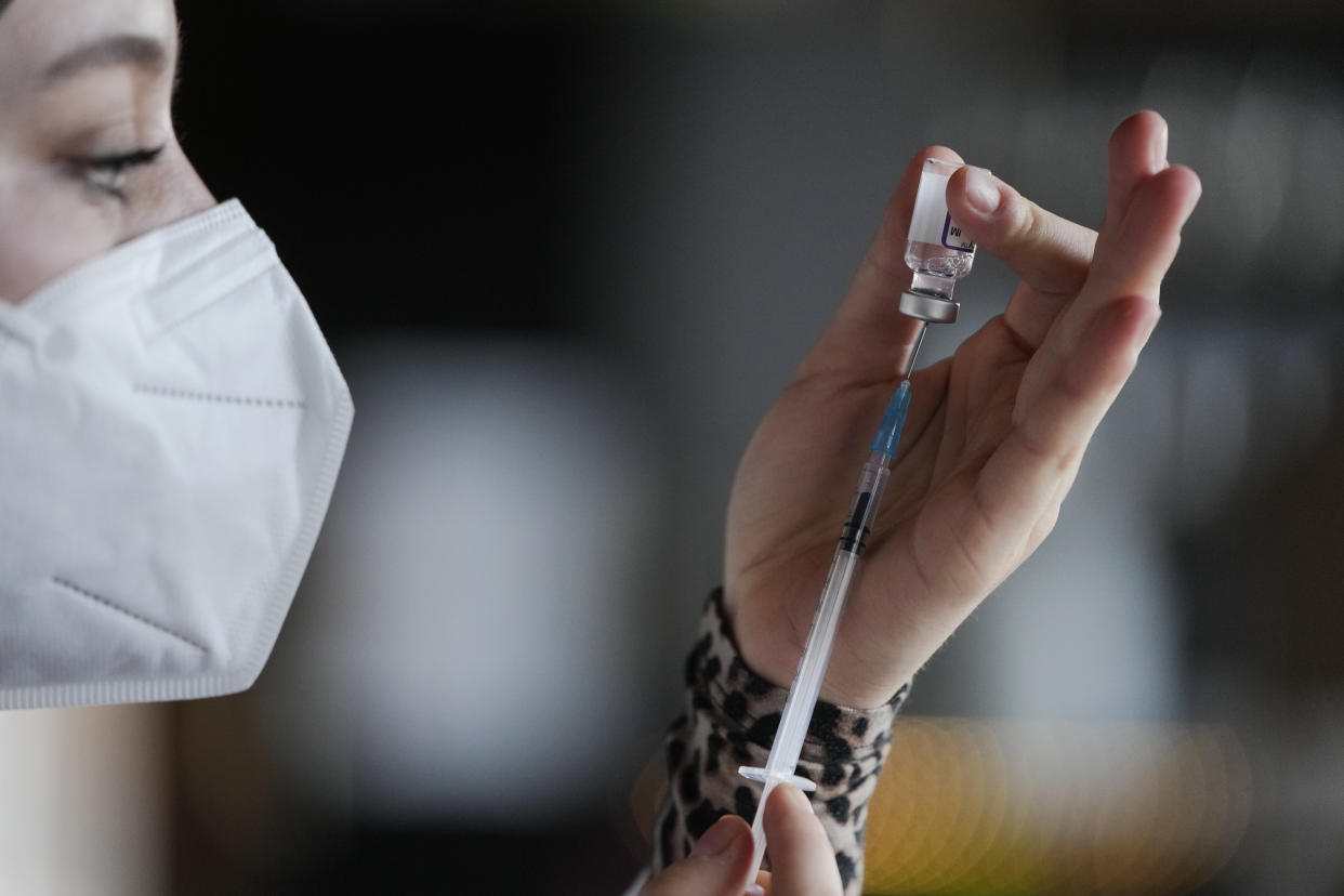 A medical student prepares a syringe with vaccination against the coronavirus and the COVID-19 disease inside Klunkerkranich Restaurant and night club during an ongoing vaccination campaign of the Clubkommission in Berlin, Germany, Wednesday, Jan. 5, 2022. German Health Minister Karl Lauterbach renewed an appeal for vaccine holdouts to reconsider. He said people who remain unvaccinated in Germany can't expect contact restrictions for them to be lifted 