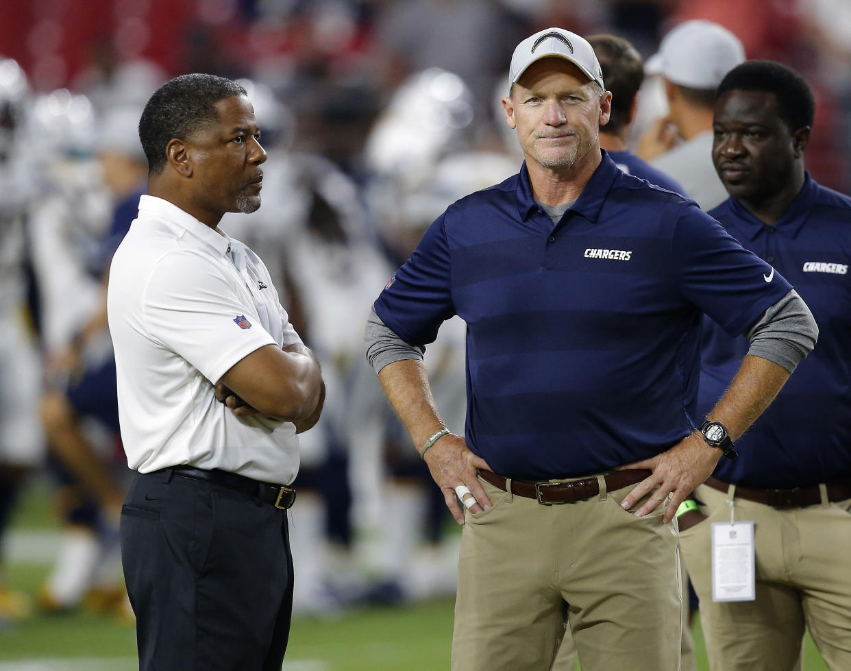 Arizona Cardinals head coach Steve Wilks, left, talks with Los Angeles Chargers assistant coach Ken Whisenhunt prior to an preseason NFL football game, Saturday, Aug. 11, 2018, in Glendale, Ariz. (AP Photo/Ross D. Franklin)