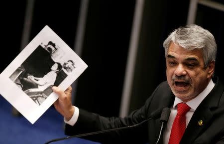 Senator Humberto Costa shows a picture of Brazil's President Dilma Rousseff at the time when she was arrested by the military government during a voting session on the impeachment of Rousseff in Brasilia, Brazil, May 12, 2016. REUTERS/Ueslei Marcelino