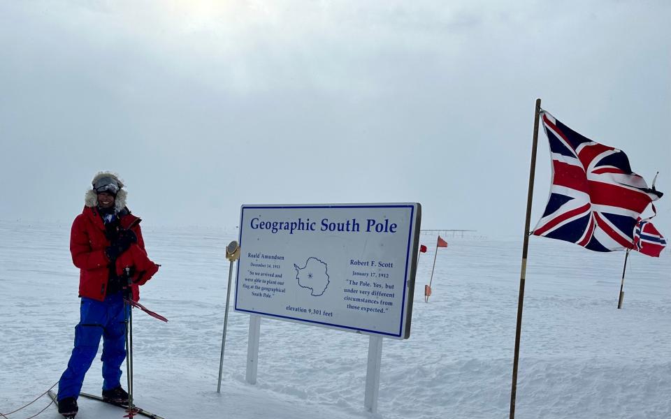 Capt Chandi poses beside the South Pole signpost at the end of her expedition