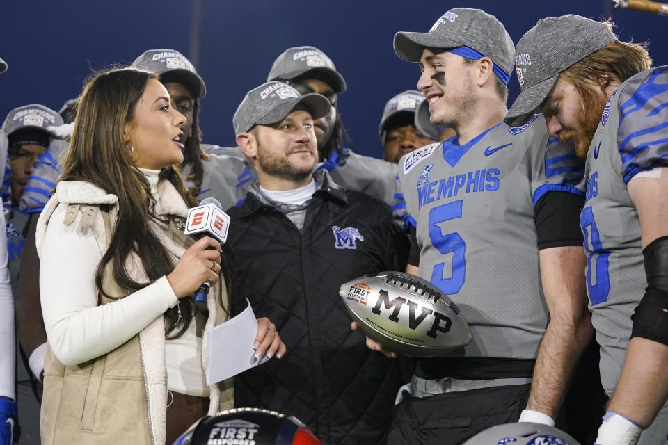 Memphis quarterback Seth Henigan (5) receives the MVP trophy following the First Responder Bowl NCAA college football game against Utah State, Tuesday, Dec. 27, 2022, in Dallas. (AP Photo/Sam Hodde)