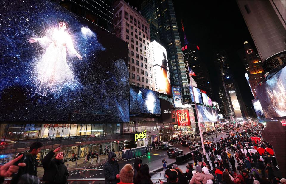 People look over the Light The World Giving Machines unveiling on the billboards in Times Square in New York City on Monday, Nov. 27, 2023. | Jeffrey D. Allred, Deseret News