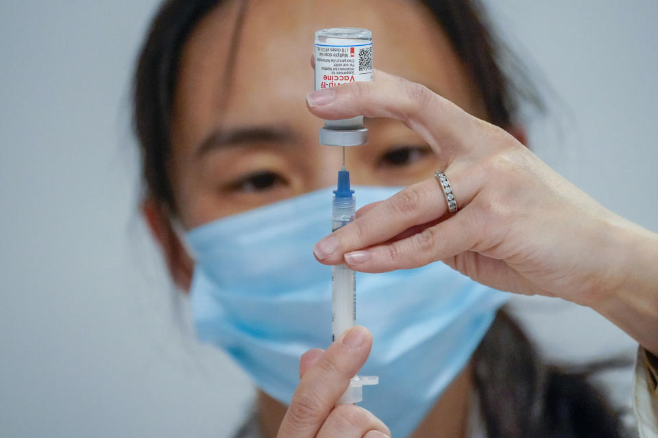 FILE - In this March 18, 2021, file photo, Pharmacist Mia Yu fills a syringe with the Moderna COVID-19 vaccine at a pop up site at Commonpoint Queens The Hub in partnership with the UJA- Federation of New York. Vaccines lessen the risk of severe illness or death from COVID-19, but scientists are still studying how well they prevent the spread of the virus. (AP Photo/Mary Altaffer, File)