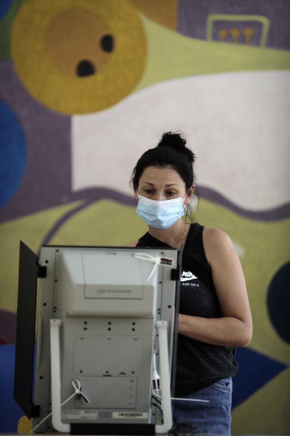 A woman casts her her vote at a polling station in Sofia, Sunday, July 11, 2021. Bulgarians are voting in a snap poll on Sunday after a previous election in April produced a fragmented parliament that failed to form a viable coalition government. (AP Photo/Valentina Petrova)