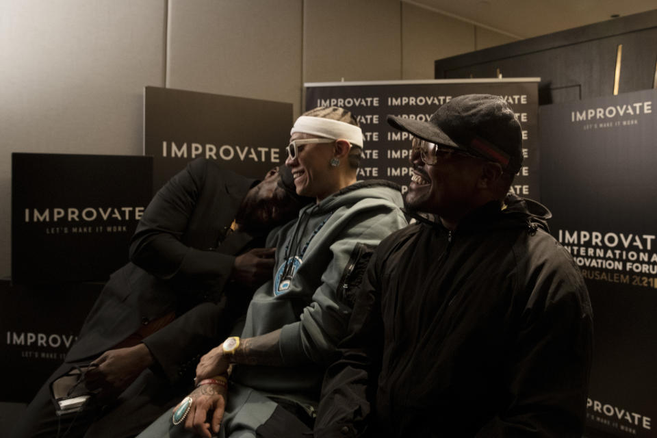 American musician will.i.am, left, laughs with his bandmates Taboo, center, and apl.de.ap, during an interview with the Black Eyed Peas, in Jerusalem, Monday, Nov. 29, 2021. will.i.am said Monday that politics don’t dictate his actions, with pressure from pro-Palestinian activists unable to deter him from performing in Israel. (AP Photo/Maya Alleruzzo)