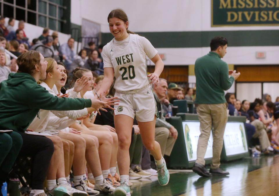 Iowa City West’s Sasha Baldwin (20) receives high-fives from teammates as she comes off the court on Tuesday. City West is 4-4, winning four of their last five games.