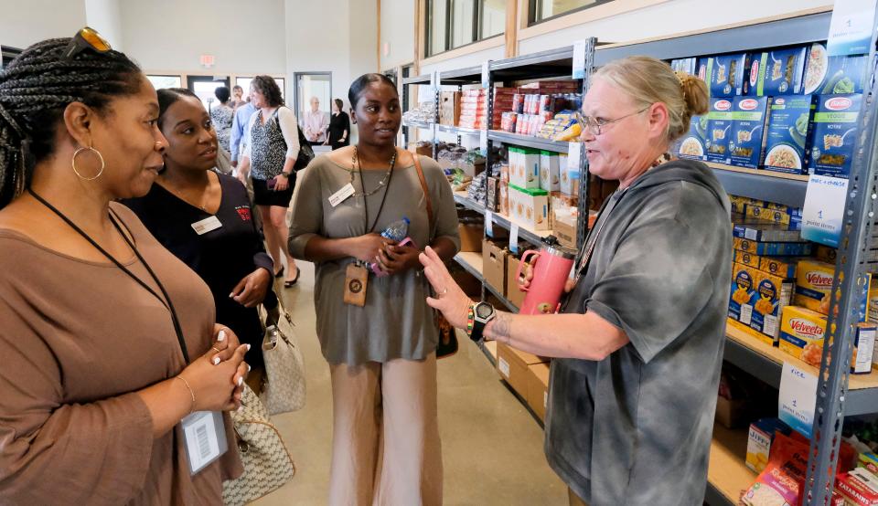 Demonica Walker, Kendalyn Jefferson, and Destiny Montgomery from the West Alabama Food Bank, get a tour during the opening of the Table of Grace client-choice pantry Thursday, Sept. 28, 2023, in Tuscaloosa from the manager, Jennifer Sheppard.