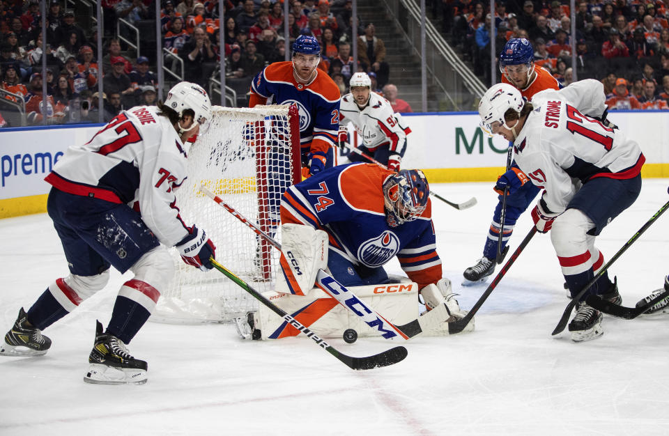 Washington Capitals' T.J. Oshie (77) is stopped by Edmonton Oilers goalie Stuart Skinner (74) as Dylan Strome (17) looks for the rebound during the first period of an NHL hockey game in Edmonton, Alberta, Monday, Dec. 5, 2022. (Jason Franson/The Canadian Press via AP)