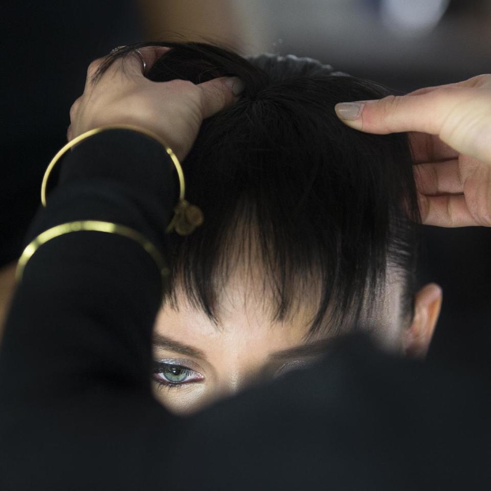 A model's hair is prepared backstage before the Carmen Marc Valvo Fall 2014 collection is modeled during Fashion Week, Friday, Feb. 7, 2014, in New York. (AP Photo/John Minchillo)