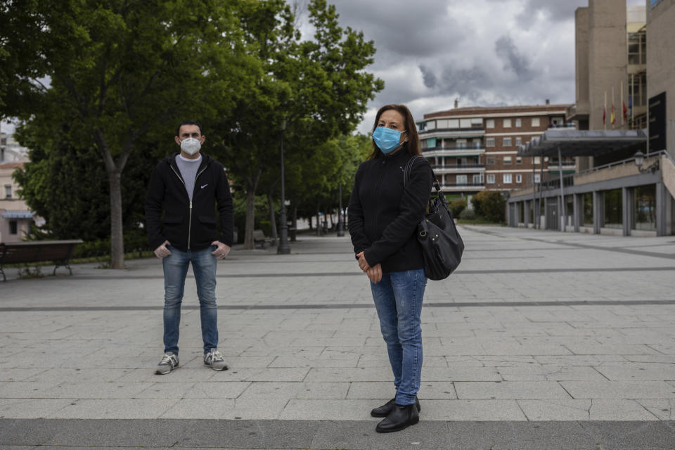 In this Friday, May 15, 2020 photo, María Mendoza, right, and Jose Manuel Martin, left, workers at the Usera Center for the Elderly, pose for portrait in Madrid, Spain. Workers at the Usera nursing home, Mendoza and Martin spoke about cost cutting and staff cuts at the Madrid nursing home where 42 people died. (AP Photo/Bernat Armangue)