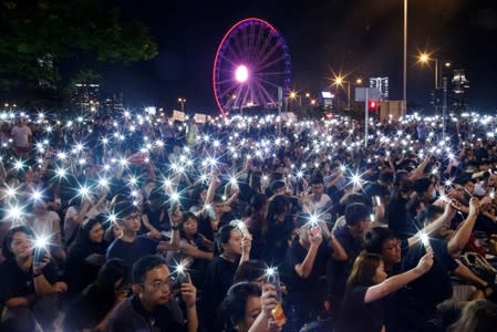 FILE PHOTO: Demonstrators wave their smartphones during a rally ahead of the G20 summit, urging the international community to back their demands for the government to withdraw a the extradition bill in Hong Kong