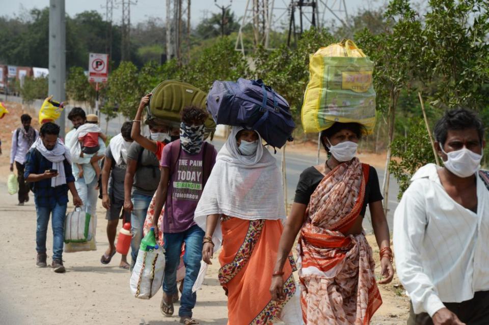 Indian migrant workers walk along a highway on the outskirts of Hyderabad, India, on April 28, 2020. | Noah Seelam—AFP/Getty Images