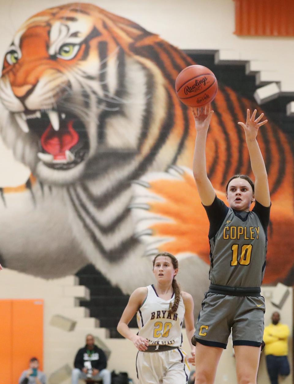 Copley's Evelyn McKnight shoots as Bryan's Marah Smith watches in a Division II regional final March 8 in Mansfield.