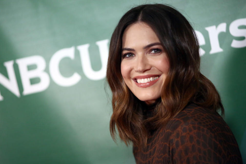 Mandy with shoulder-length hair smiles in a patterned outfit at an NBCUniversal event