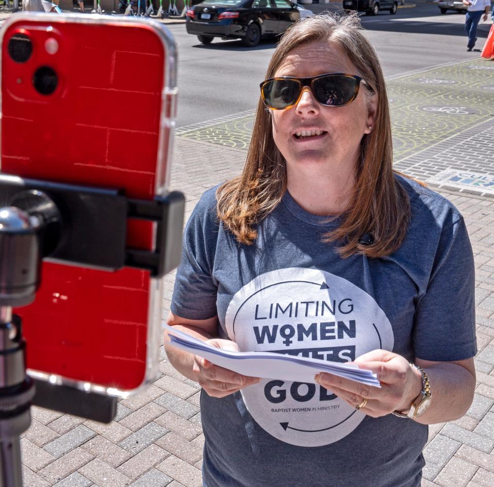 Meredith Stone, executive director with the Baptist Women in Ministry, reads community prayers of solidarity and affirmation as the group protests, while standing outside the Southern Baptist Convention, Tuesday, June 11, 2024.