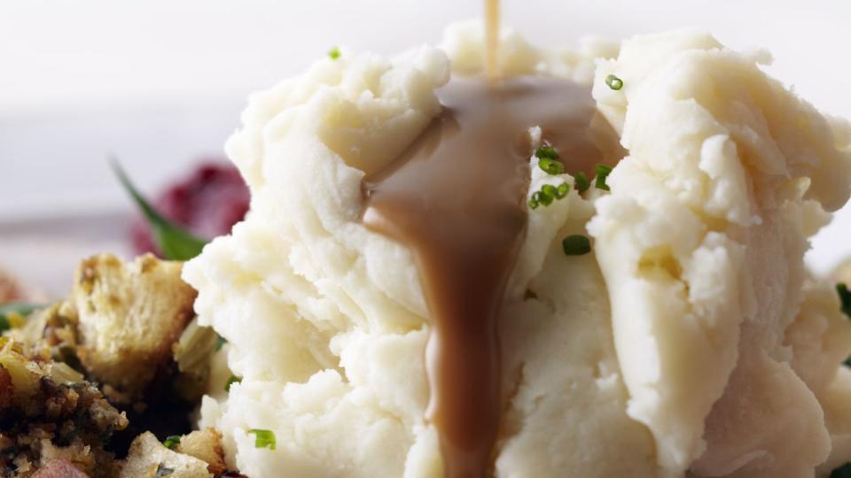gravy being poured onto mashed potatoes