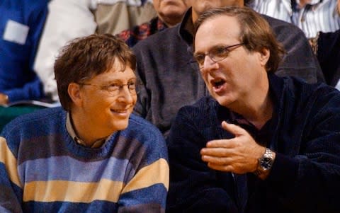 Microsoft Chairman Bill Gates, left, chats with Portland Trail Blazers owner and former business partner Paul Allen during a game between the Trail Blazers and Seattle SuperSonics in Seattle - Credit: AP