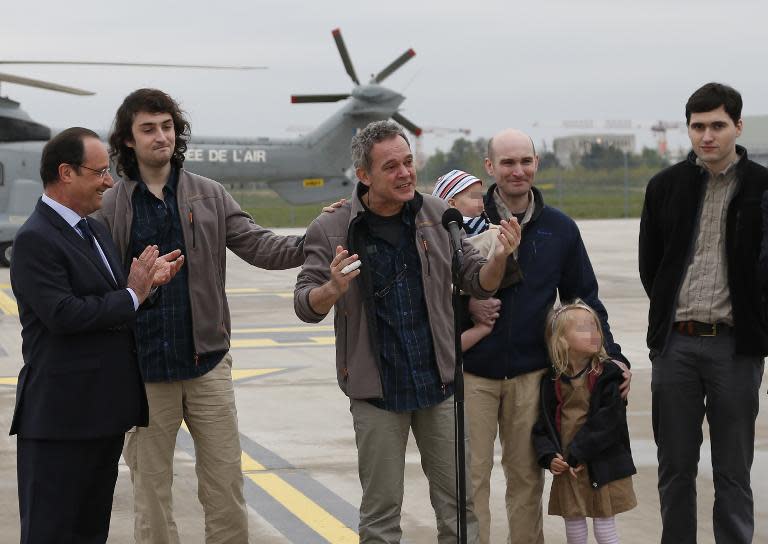 President Francois Hollande (L) welcomes French journalists Didier Francois (3L), Edouard Elias (2L), Nicolas Henin (2R) and Pierre Torres (R) at the Villacoublay air base southwest of Paris on April 20, 2014