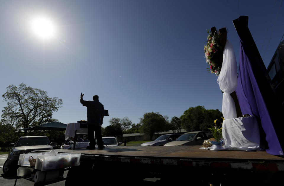 Pastor Albert "Gonzo" Gonzales stands on a flat-bed truck as his church holds Easter services in the parking log in San Antonio, Sunday, April 12, 2020. Many churches are adapting their services as Christians around the world are celebrating Easter at a distance due to the COVID-19 pandemic. (AP Photo/Eric Gay)