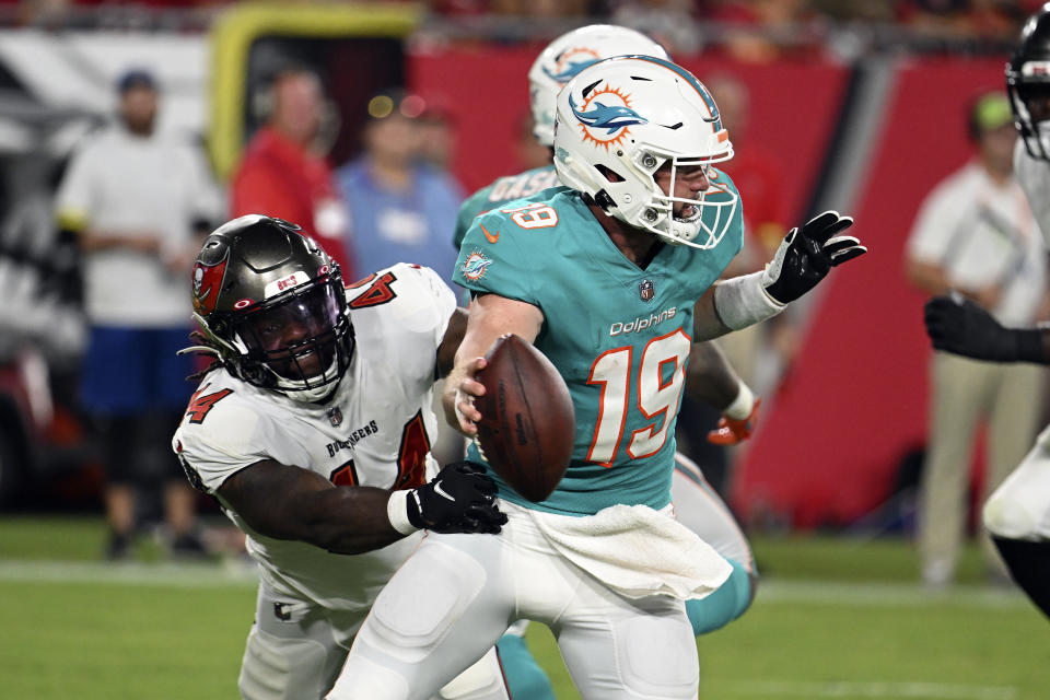 Miami Dolphins quarterback Skylar Thompson (19) tries to slip a tackle by Tampa Bay Buccaneers linebacker Elijah Ponder (44) during the second half of an NFL preseason football game Saturday, Aug. 13, 2022, in Tampa, Fla. (AP Photo/Jason Behnken)