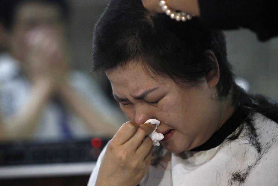 Kim Eun-ju, head of theater Hollywood Classic, reacts as she gets her hair shaved in front of patrons at Seodaemun Art Hall in Seoul, South Korea, Wednesday, July 11, 2012. Seoul's last old-style one-screen cinema, soon to be knocked down and replaced by a new tourist hotel, played its final movie Wednesday - the Italian classic "The Bicycle Thief." Kim had her head shaved in public to mark the closure of the theater. “I’m not protesting. I just want to let the people know how many happy moments we can have by having this kind of culture,” Kim said. (AP Photo/Hye Soo Nah)