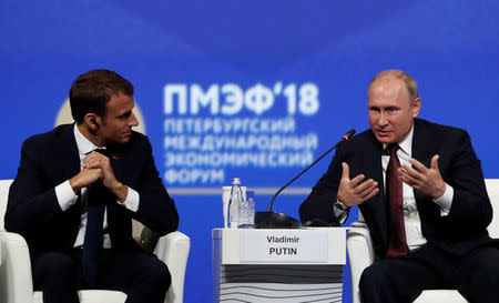 Russian President Vladimir Putin and his French counterpart Emmanuel Macron attend a session of the St. Petersburg International Economic Forum (SPIEF), Russia May 25, 2018. REUTERS/Grigory Dukor