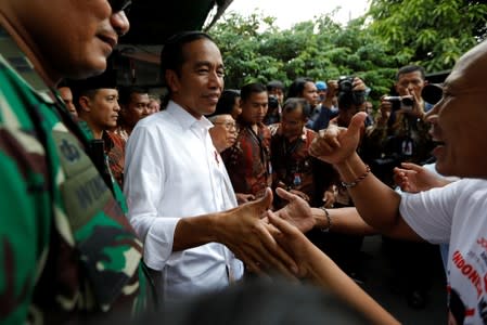 Indonesia's Incumbent President Joko Widodo and his running mate Ma'ruf Amin greet their supporters after making a public address following the announcement of the last month's presidential election results at a rural area of Jakarta