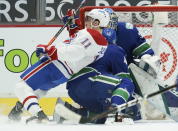 Montreal Canadiens right wing Brendan Gallagher (11) falls next to Vancouver Canucks goaltender Thatcher Demko (35) and defenseman Olli Juolevi (48) during the second period of an NHL hockey game Thursday, Jan. 21, 2021, in Vancouver, British Columbia. (Jonathan Hayward/The Canadian Press via AP)