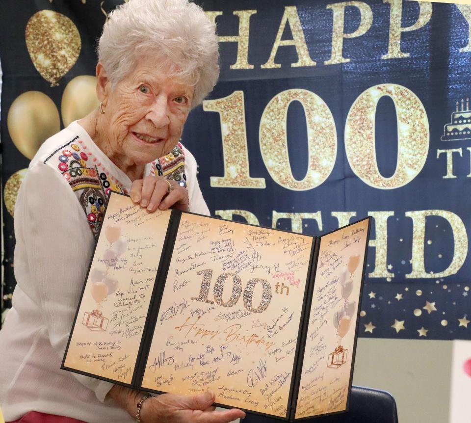 Elizabeth Parisi shows off her birthday card, Wednesday, Oct. 11, 2023, during her 100th birthday celebration at the Adult Activity Center in Port Orange.