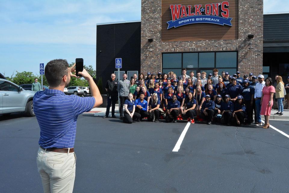 Bailey Richard, Walk-Ons Sports Bistreaux regional marketing, takes a photo in May of the Columbia restaurant's staff as it celebrated its grand opening at 2541 Broadway Bluff Drive, the former home of Houlian's.