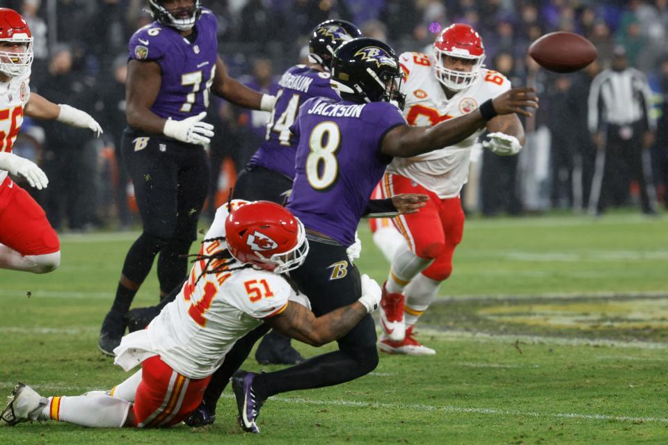 Baltimore Ravens quarterback Lamar Jackson (8) passes the ball while being tackled by Kansas City Chiefs defensive end Mike Danna (51) during the third quarter in the AFC Championship football game at M&T Bank Stadium.