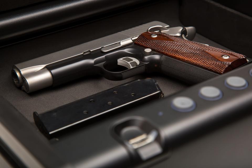 A .45-caliber handgun and loaded clip sits in a fingerprint safe box.