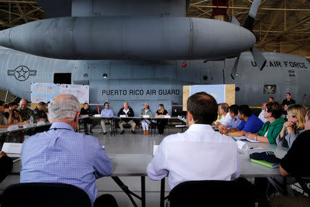 U.S. President Donald Trump receives a briefing on hurricane relief efforts in a hangar at Muniz Air National Guard Base in Carolina, Puerto Rico, U.S. October 3, 2017. REUTERS/Jonathan Ernst