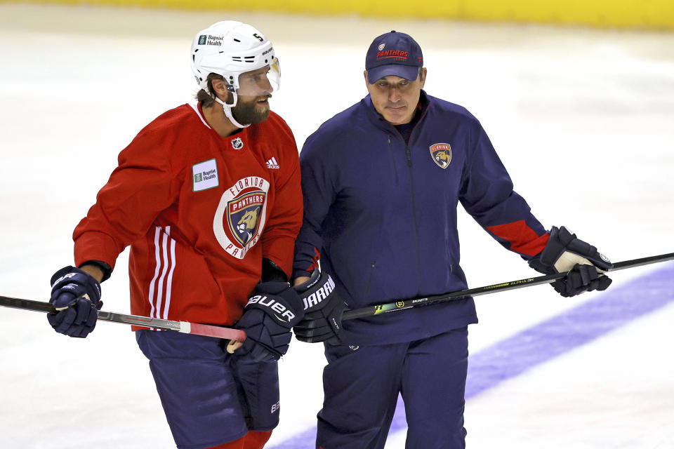 FILE - Florida Panthers assistant coach Andrew Brunette, right, skates with defenseman Aaron Ekblad (5) during NHL hockey training camp on Sept. 23, 2021, in Sunrise, Fla. Brunette spent four years playing for Joel Quenneville, and until Thursday night, Oct. 28, 2021, worked for Joel Quenneville. He's now - at least on an interim basis - taking over for Quenneville, who resigned Thursday night over his role in how the Chicago Blackhawks largely ignored a player's sexual assault claims against another coach 11 years ago. (David Santiago/Miami Herald via AP, FIle)