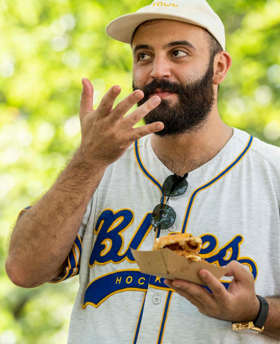 Rateb Aburas, executive chef of Mulberry Street Tavern and the Surety Hotel Des Moines, takes a bite out of the OMG chicken sandwich from Chicken City at the Iowa State Fair.