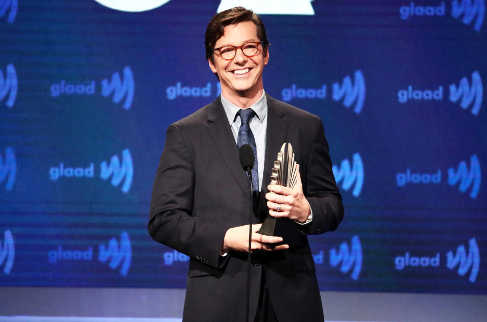 Sean smiling at a podium and holding an award