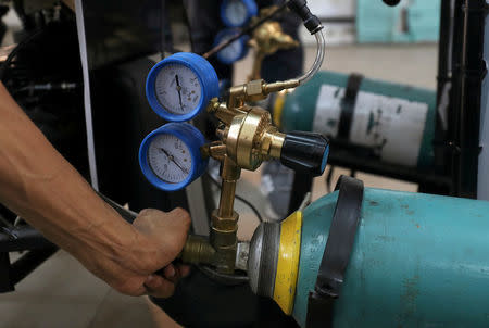 Mechanical engineering student from Helwan University turns the valve of air tank on the air-powered vehicle which was designed to promote clean energy and battle increasing gas prices, in Cairo, Egypt August 7, 2018. Picture taken August 7, 2018. REUTERS/Mohamed Abd El Ghany