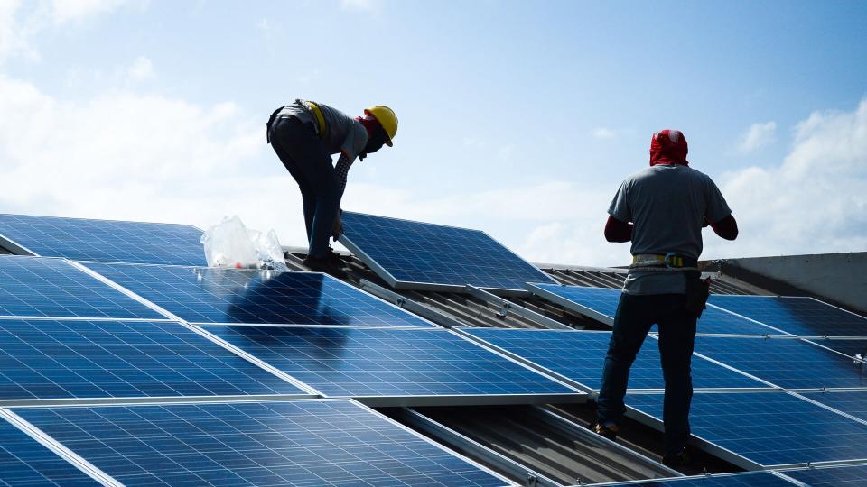 workers installing solar panels