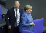 German Finance Minister Olaf Scholz left, and German Chancellor Angela Merkel, right, arrive for a meeting of the German federal parliament, Bundestag, at the Reichstag building in Berlin, Germany, Wednesday, Sept. 11, 2019. (AP Photo/Michael Sohn)