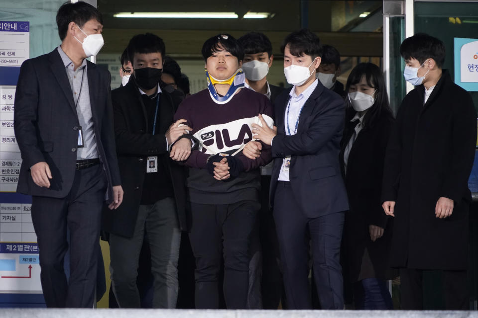 Cho Ju-bin, center, leader of South Korea's online sexual blackmail ring which is so called "Nth room," walks out of a police station as he is transferred to prosecutors' office for further investigation in Seoul, South Korea, Wednesday, March 25, 2020. South Korean prosecutors on Wednesday began reviewing whether to formally charge a man arrested last week on allegations he operated secretive chatrooms where he posted sexually abusive videos of blackmailed women in return for cryptocurrency payments. (Kim Hong-Ji/Pool Photo via AP)