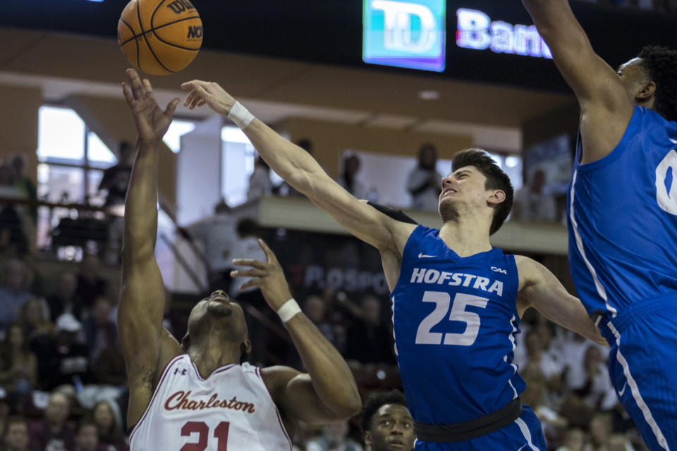 Hofstra guard German Plotnikov (25) blocks a shot by Charleston guard Jaylon Scott (21) during the first half of an NCAA college basketball game, Saturday, Jan. 28, 2023, in Charleston, S.C. (AP Photo/Stephen B. Morton)