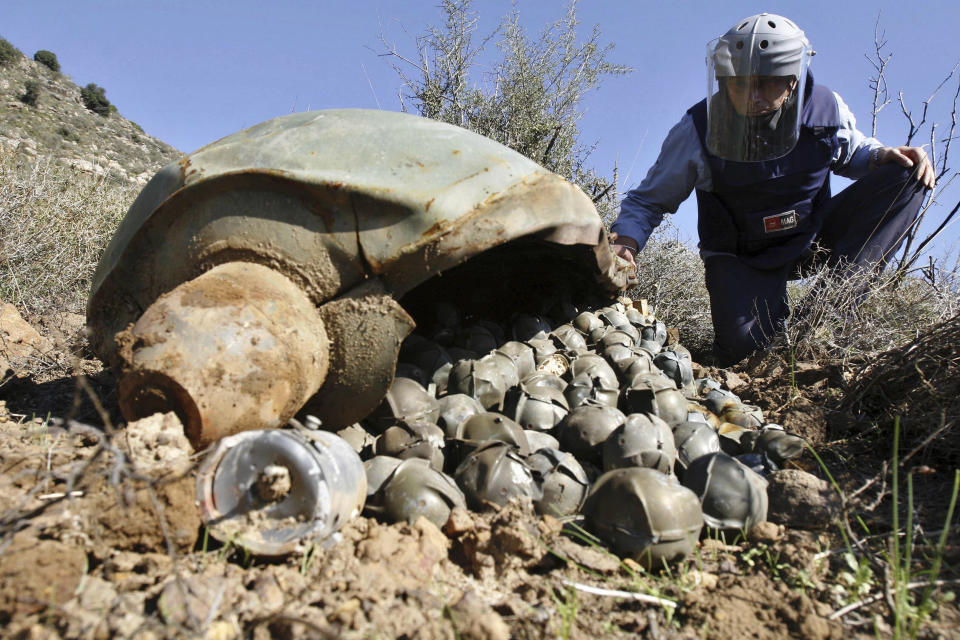 FILE - Mines Advisory Group Technical Field Manager Nick Guest inspecting a Cluster Bomb Unit in the southern village of Ouazaiyeh, Lebanon, on Nov. 9, 2006, that was dropped by Israeli warplanes during the 34-day long Hezbollah-Israeli war. Backers of an international agreement that bans cluster munitions are striving to prevent erosion in support for it after what one leading human rights group calls an “unconscionable” U.S. decision to ship such weapons to Ukraine for its fight against Russia. Advocacy groups in the Cluster Munitions Coalition released their latest annual report on Tuesday Sept. 5, 2023. (AP Photo/Mohammed Zaatari, File)